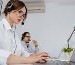 Focused customer support professionals working in a modern office with headsets and laptops.