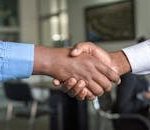 Close-up of two men's handshake symbolizing agreement in an office.